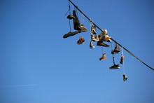 Shoes Hanging On A Rope Against The Blue Sky