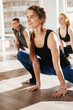© Drobot Dean - Smiling beautiful young woman practicing yoga in group