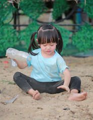 Wall Mural - adorable little girl playing in garden with soil