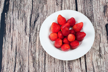 strawberries on a white plate. warm background