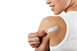 © Stasique - Smiling woman taking off adhesive bandage from healed arm.