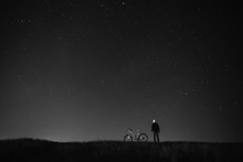 Black And White Art Photography Monochrome, Starry Sky, Night Photography, Astrophotography, The Silhouette Of A Man, A Man Standing Next To A Mountain Bike On The Background Of A Starry Sky