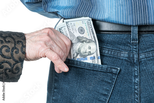 Fotografía Senile hand puts dollars in the back pocket of jeans strangers, isolated on a wh