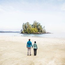 Couple Looking Out At Island From Long Beach, Pacific Rim National Park, Vancouver Island, British Columbia, Canada