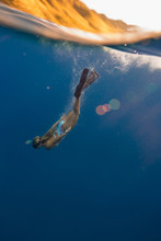 Woman Wearing Flippers Swimming Underwater, Oahu, Hawaii, USA