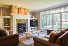 Brown Leather Sofa, Sitting Chairs And Natural Stone Fireplace In The Living Room Inside A Cottage Style Home, Quebec, Canada