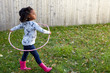 © Connect Images - Cute girl playing in garden with plastic hoop
