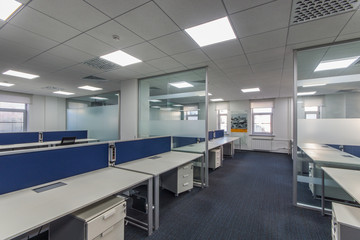 Modern office interior with multiple open-plan work stations at long desks