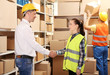 © Africa Studio - Two business people shaking hands at warehouse