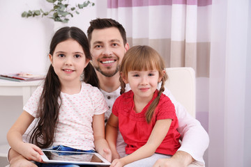 Wall Mural - Father with daughters on sofa in the room