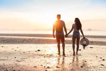 Wall Mural - couple on beach at sunset summer vacation, beautiful young people in love walking, man woman holding