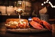 Lobster and lobster sandwich served with wine. Seafood dinner in a restaurant 