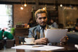 © Johnstocker - Businessman reading newspaper and having coffee at cafe.