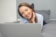 © Proxima Studio - Woman lies on the bed with a laptop