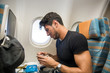 © theartofphoto - Young man feeling disgusted after tasting insipid food in the airplane. Horizontal indoors shot.