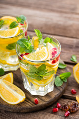 Lemon mojito cocktail with mint and pomegranate, cold refreshing drink or beverage