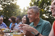 © Monkey Business - Group Of Mature Friends Enjoying Outdoor Meal In Backyard