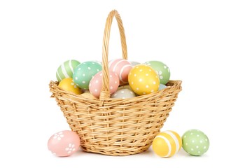 Easter basket filled with hand painted pastel Easter Eggs over a white background