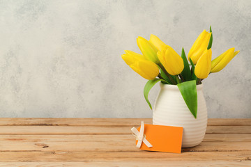 Wall Mural - Tulip flower bouquet on wooden table over rustic background