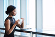 © nakophotography - Elegant African American woman thoughtfully looking out the large window while holding her cup of tea in her hands, resting one elbow on the counter maintaining regal posture