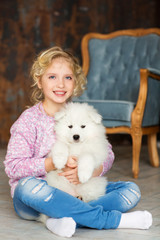 Poster - Little girl with a samoyed puppy