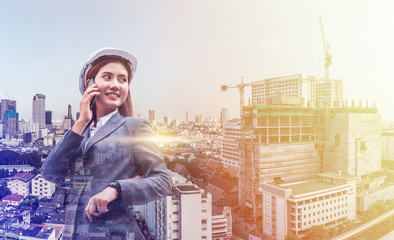 Wall Mural - Portrait of beautiful young engineer woman wear a white safety helmet. She are smile and talking on smartphone with commitment to success, double exposure with construction site background