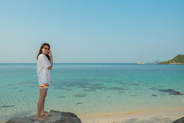 Wall Mural - young woman happy standing on the rock at the beach