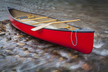 Red Canoe On A Shallow Rocky River