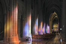 Light Streaming Through Stained Glass Windows With Colourful Light Columns Along The Cathedral Nave, Altarpiece In St. Mary's Chapel Visible Background; Washington, District Of Columbia, United States Of America
