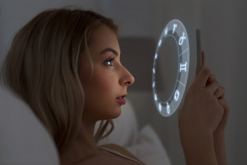young woman reading horoscope on smartphone