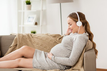 Pregnant Woman With Headphones Listening To Music