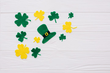 Traditional Irish St. Patrick's Day symbols hat, clover leafs and coins on wooden background .Space for your text