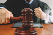 justice and law concept.Male judge in a courtroom with the gavel,working with smart phone,digital tablet computer docking keyboard,eyeglasses,on wood table,filter