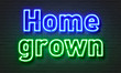 Home grown neon sign on brick wall background.