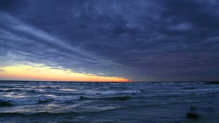 Wall Mural - looping video features a dramatic cloudy sky at sunset over lake michigan with rolling waves coming 