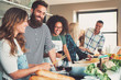 © Flamingo Images - Group of friends cooking at kitchen.
