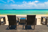 Fototapeta Do akwarium - Beach chairs on the white sand beach at summer terrace restaurant
