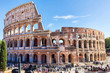Ruins of the colosseum in Rome, walking visitors and tourists, sunny day with blue sky, Italy