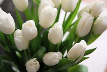 A Large Bouquet Of White Tulips With Green Leaves