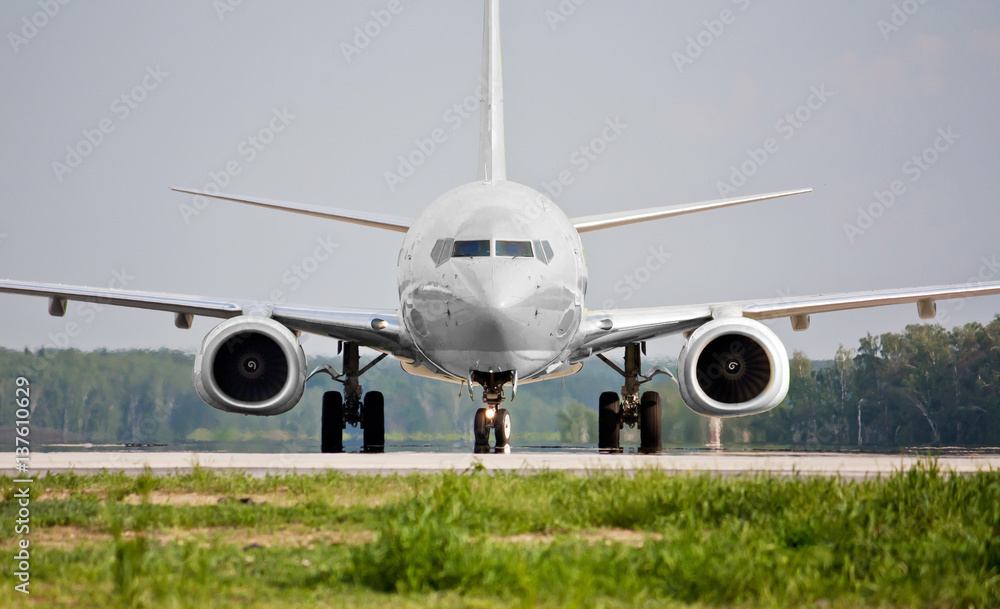 Front view of white plane before takeoff on the runway. Passenger airliner takes off. Passenger commercial air transportation. Mid-range aircraft. Spotting in the airport. - obrazy, fototapety, plakaty 