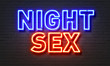 Night sex neon sign on brick wall background.