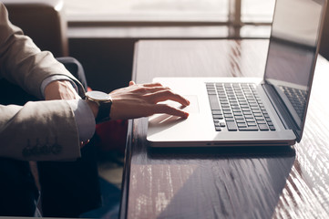 a young man touches the touchpad of the laptop