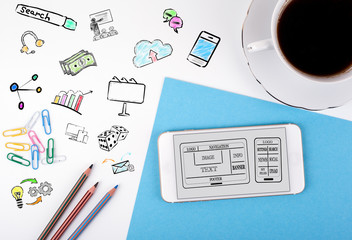 Wall Mural - website and mobile app development concept. mobile phone and coffee cup on a white office desk.
