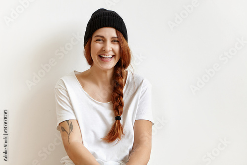 Indoor Portrait Of Fashionable And Cheerful Young Woman With Braid