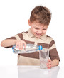 © DenisNata - Portrait of cheerful little boy with glass and plastic bottle of water. Cute smiling child drinks water, isolated on white background.