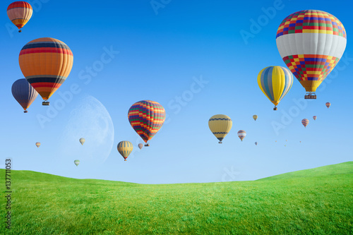 Zdjęcie XXL Gorące powietrze szybko się zwiększać latanie w jasnym niebieskim niebie nad zielonej trawy pole
