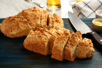 Wall Mural - Board with tasty loaf of beer bread on wooden table