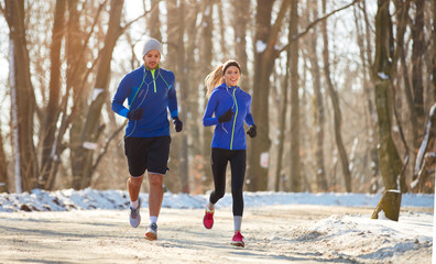 couple in winter running together in nature