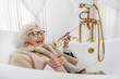 © Yakobchuk Olena - Joyful mature lady relaxing in bathtub
