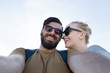 © Myvisuals - Capturing bright moments. Joyful young loving couple making selfie on camera while standing outdoors